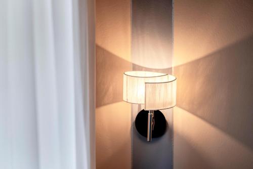 a lamp on a wall next to a curtain at Hotel Bellevue in Gardone Riviera