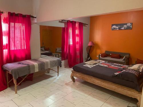 een slaapkamer met 2 bedden en rode gordijnen bij Appartement T3 Bandrélé in Bandrélé