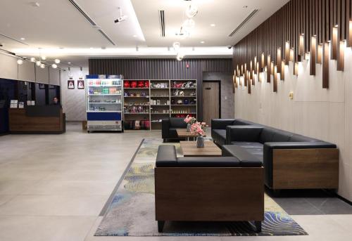 a store lobby with couches and flowers on a rug at Kingsgate Canal Hotel by Millennium in Dubai