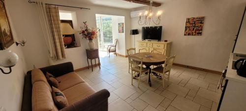 a living room with a couch and a table at Appartements de charme La Sarrazine in La Garde-Freinet