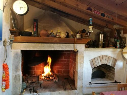 a brick fireplace with a clock on top of it at Sundial Stone House in Ždrelac