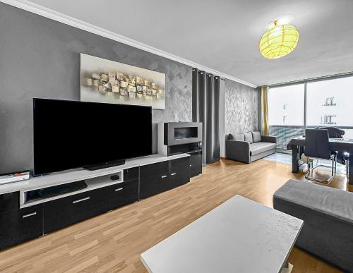 een woonkamer met een grote flatscreen-tv bij Le Lumineux - Proche centre-ville et Atlantis in Saint-Herblain