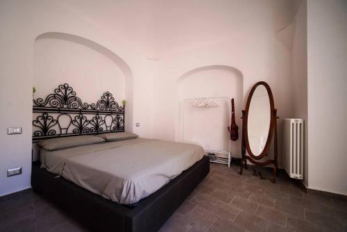 een slaapkamer met een groot bed en een spiegel bij Nerano Casa Adelaide in Nerano