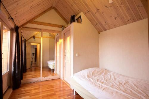 a bedroom with a white bed and a wooden ceiling at Large, central and quiet apartment. in Stavanger