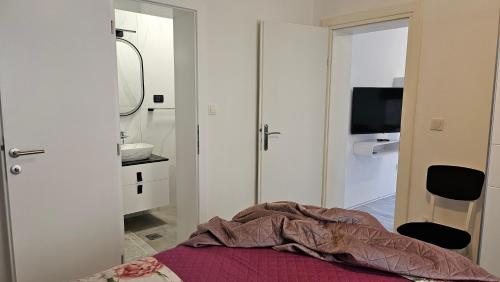 a bedroom with a bed and a sink and a mirror at Katy in Krk
