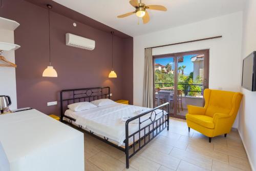- une chambre avec un lit et une chaise jaune dans l'établissement Sea Garden, à Kaş