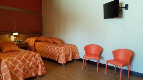 サリーチェ・サレンティーノにあるLeone de Castris Wine Hotelのベッドルーム1室(ベッド2台、赤い椅子2脚付)