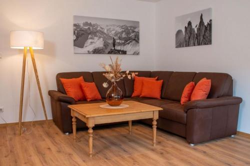 Una sala de estar con un sofá marrón y una mesa. en Ferienwohnung Bergnasennen, en Pfronten