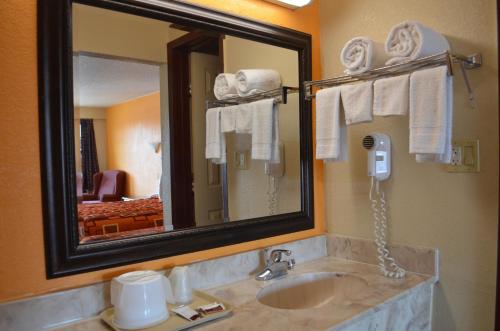 a bathroom with a sink and a mirror and a phone at Royal Inn Greenville in Greenville