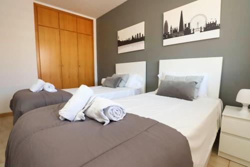 a bedroom with two beds with towels on them at DIFFERENTFLATS Costa d' Or II in Cambrils