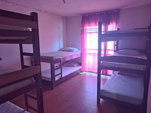 a room with three bunk beds and a window at Assel Xaxim Ap1Q Empreiteiras in Curitiba