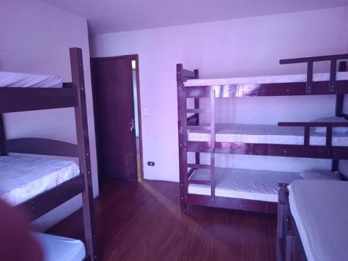 Zimmer mit 3 Etagenbetten und einer Tür in der Unterkunft Assel Xaxim AP2 Curitiba in Curitiba