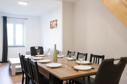 a dining room with a wooden table and chairs at Le Havre Tervillois in Terville