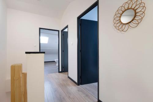 un couloir avec des portes bleues et un miroir dans l'établissement Le Havre Tervillois, à Terville