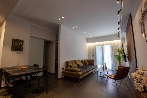 salon z kanapą i stołem w obiekcie Carmen's cozy&luxury apartment! w Atenach