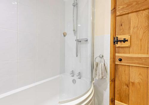 y baño blanco con bañera y ducha. en Stanegate at Hadrians Wall, en Irthington