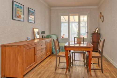 une salle à manger avec une table et une commode dans l'établissement La Baule, à La Baule