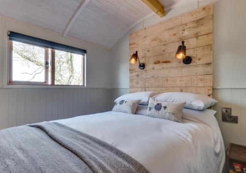 1 dormitorio con 1 cama grande y pared de madera en Esk Escape, en Longtown