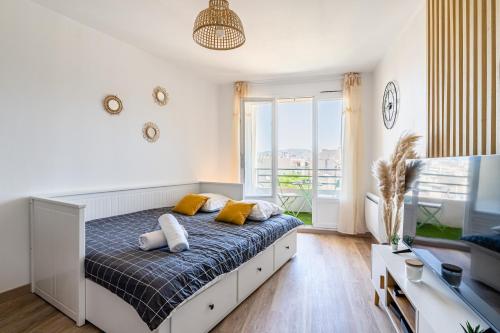 une chambre avec un lit avec des oreillers jaunes et une fenêtre dans l'établissement St Charles : Confortable+ Balcon, à Marseille