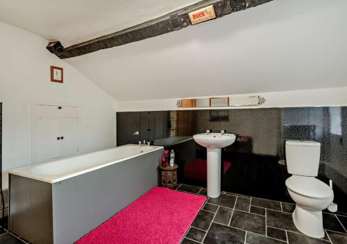 a bathroom with a tub and a toilet and a sink at Pear Tree Cottage - Solway Coast in Bowness-on-Solway