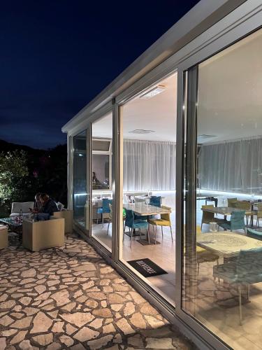 uma casa com portas de vidro deslizantes e um pátio em Casale Romano Resort e Relais em Motta Camastra