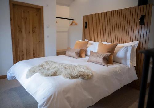 a large white bed with a pile of pillows at Beltie in the Vale in Threlkeld