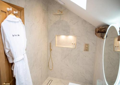 a bathroom with a white robe hanging on a wall at Beltie in the Vale in Threlkeld