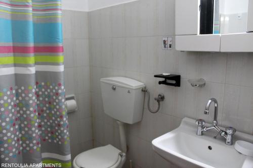 a bathroom with a toilet and a sink at Rentoulia Apartments in Poulithra