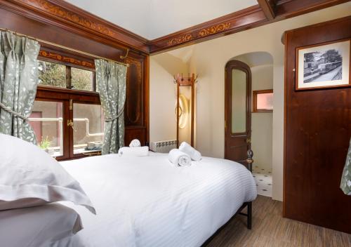 a bedroom with a white bed and a window at Esk Pullman Carriage in Ravenglass