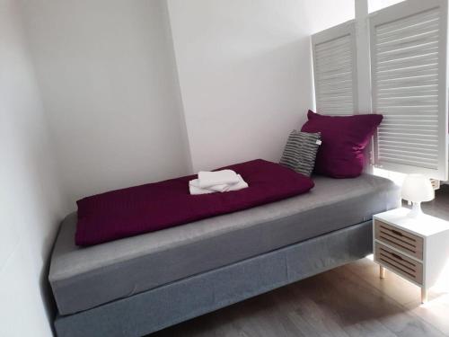 a bed in a room with purple pillows at Villa Mariensiel 2OG li in Sande