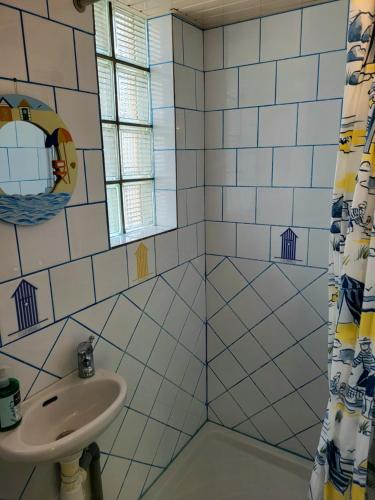 une salle de bain avec un lavabo et un miroir dans l'établissement Maison de plage la grise brèche, à Pirou