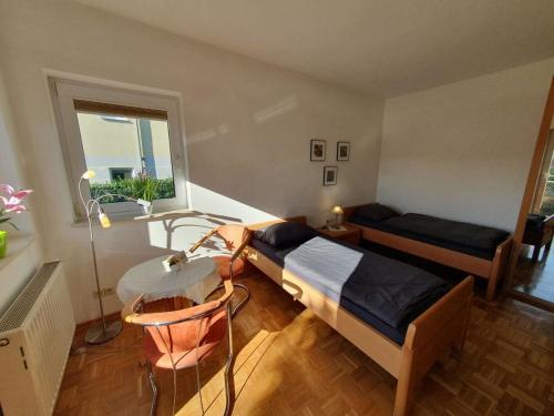 a bedroom with a bed and a table and a window at 17 Apartments und 2 Suiten in Zwingenberg