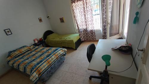 a bedroom with a bed and a desk and a table at Godoy cruz hause in Godoy Cruz