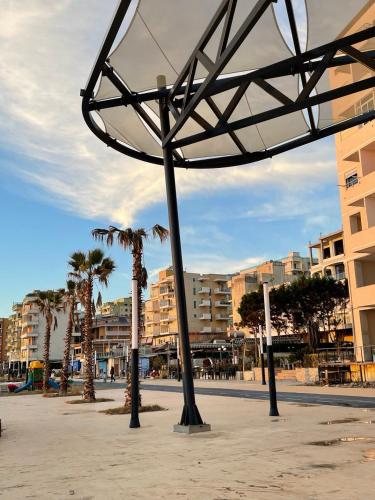 a group of poles with palm trees and buildings at Irene Beach Apartment in Durrës