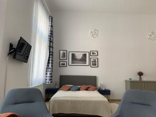 a bedroom with a bed and two blue chairs at Charming Central Apartments in Cluj-Napoca