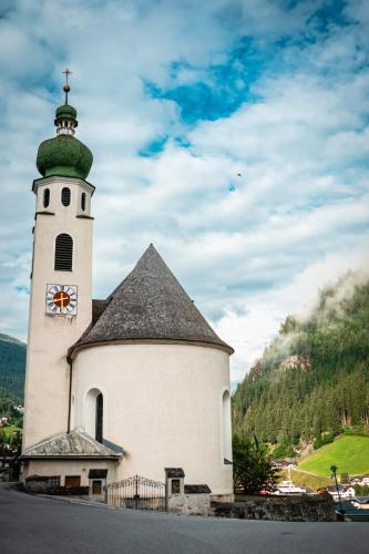 a church with a tower with a clock on it at Hotel Buckelhof - See - only 20 min from Ischgl in See
