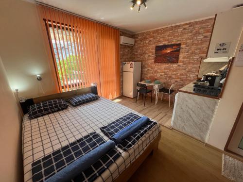 Cet appartement comprend une chambre avec un lit et une cuisine avec une table. dans l'établissement Studio VILI, à Varna