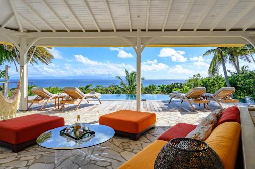 an outdoor patio with a couch and tables and chairs at Villa Calico in Les Basses