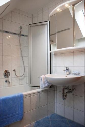 biała łazienka z umywalką i prysznicem w obiekcie Komfortable Ferienwohnung in Ebensfeld mit Garten und Grill w mieście Ebensfeld