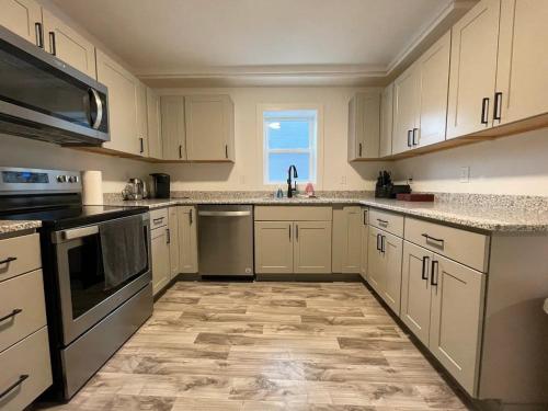 a large kitchen with white cabinets and a window at 2 Bedroom Apartment, Walk To Mayo, Free Parking in Rochester