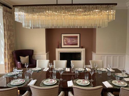 a dining room with a table with chairs and a chandelier at Idyllic Country House in Haslemere in Haslemere