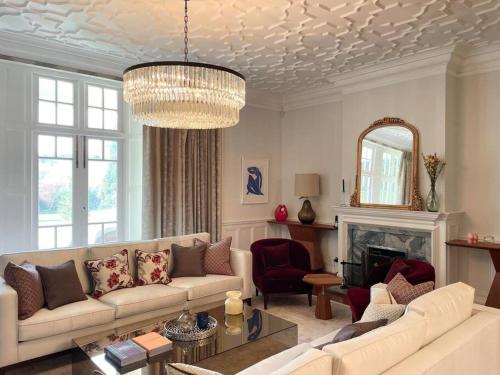 a living room with a couch and a chandelier at Idyllic Country House in Haslemere in Haslemere