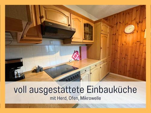 uma cozinha com armários de madeira e um forno com placa de fogão em Attraktives Ferienhaus im Grünen em Falkensee