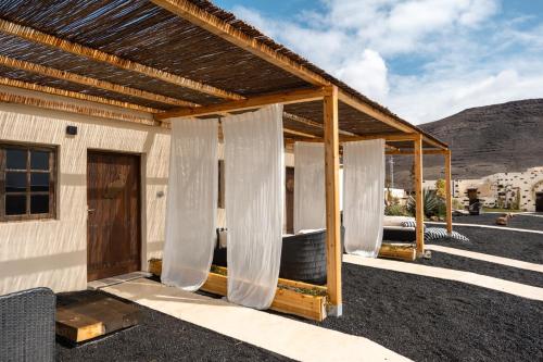 a house with white curtains on the side of it at Finca Luz in Puerto del Rosario
