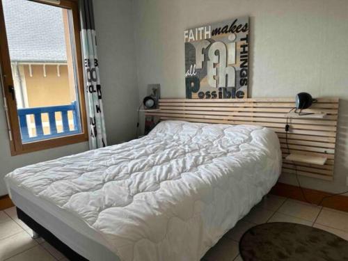 un grand lit dans une chambre avec une fenêtre dans l'établissement Appartement T2 Agatha Christie, à Dinard