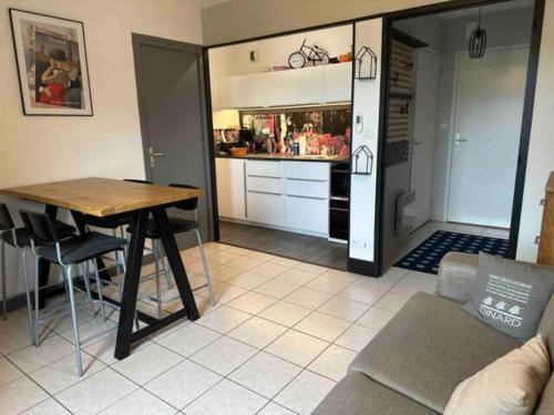 un salon avec une table et une cuisine dans l'établissement Appartement T2 Agatha Christie, à Dinard