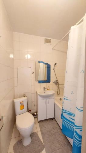 a bathroom with a toilet and a sink and a tub at Двухкомнатная 19-7 in Atyraū