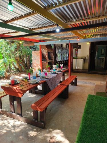 a patio with a long wooden table and benches at Shangrila-innibos Country Lodge in Hartbeespoort