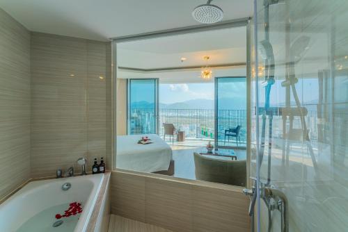 a bathroom with a tub and a large window at Best View Panorama Condotel managed by MLB in Nha Trang