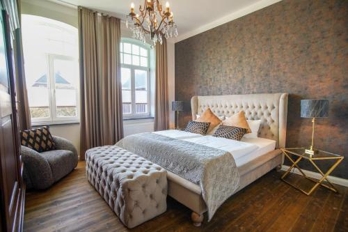 a bedroom with a bed and a chair and a chandelier at FeWo Lina in Borkum